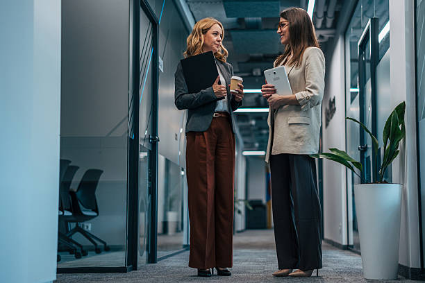 istock Business colleagues having discussion in modern office hallway 2247744606