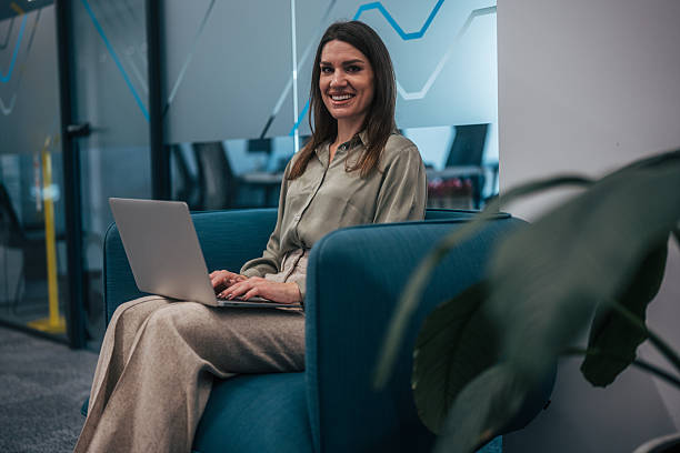 istock Businesswoman smiling while working on laptop in modern office 2247744634