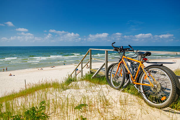 istock Two bright orange bicycles parked on a grassy dune overlooking a beautiful white sand beach and the Baltic sea, symbolizing active travel and seaside recreation on the Curonian spit 2247745601