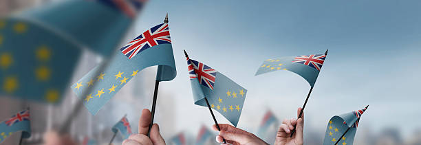 istock Tuvalu flags in their hands on a blurred urban background 2247747073