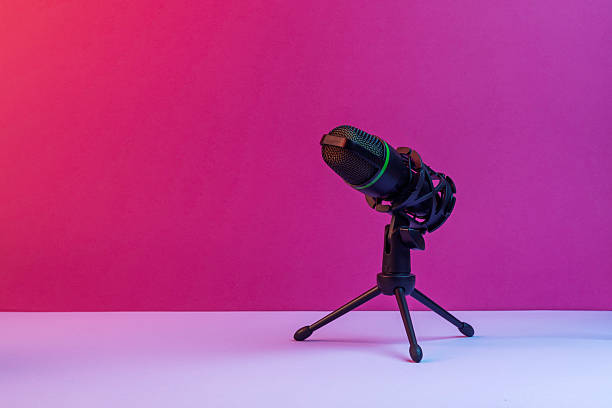 istock Studio microphone on tripod stands against vibrant pink backdrop forming clean modern setup for podcasts, streaming and audio content 2247749269