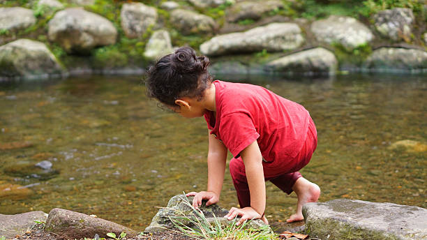 istock A daughter playing in a river with red clothes 2247749489