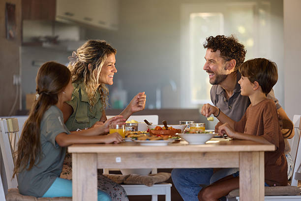 istock Happy family talking during breakfast at dining table. 2247750828