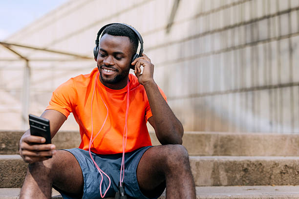 istock Handsome athlete using smartphone and headphones outdoors 2247750896