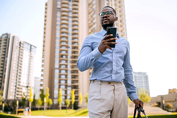 istock Well dressed businessman using smart phone while walking outdoors in a city 2247752143