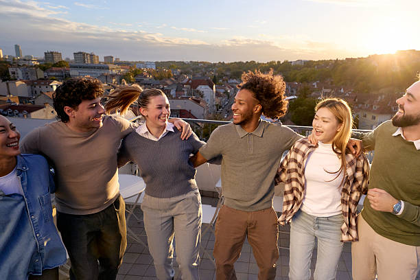 istock Cheerful colleagues having fun on a rooftop party after work at sunset. 2247753220