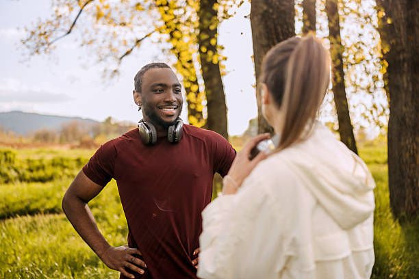 istock Cheerful couple talking while taking a break from running in nature during sunny day 2247753399