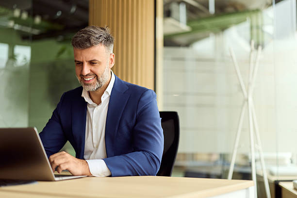 istock Confident Business Professional in Blue Suit Working on Laptop in Modern Office Setting 2247753507