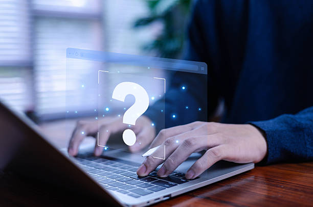 istock Business professional typing on a laptop with a futuristic question mark icon, symbolizing digital help, online support, problem solving, knowledge search, and modern technology assistance. 2247754228