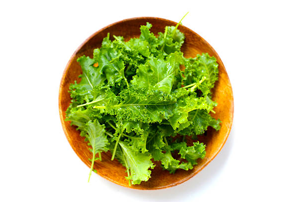 Fresh curly green kale leaves on white background.
