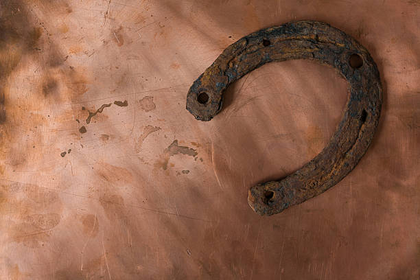istock Minimalist photo of an old rusty horseshoe on a worn copper background. 2247757030