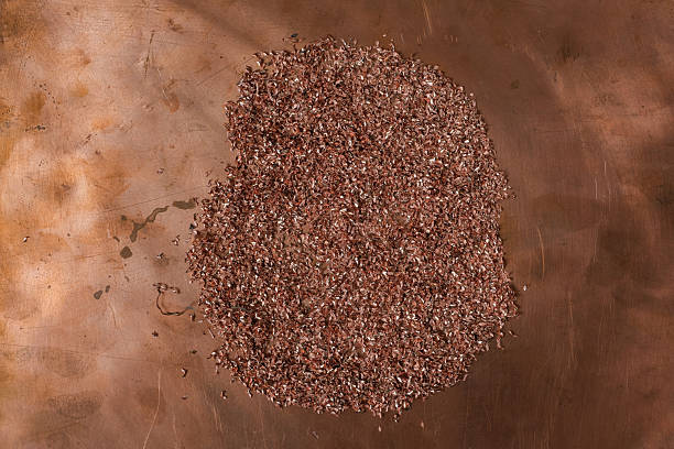 Copper shavings on a scratched copper metal surface.