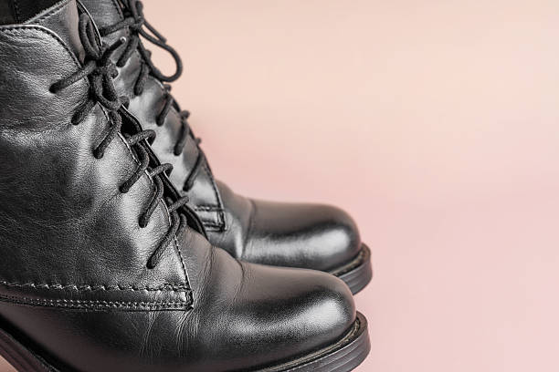 istock Stylish black elegant leather boots on pink beige background with copy space 2247757503