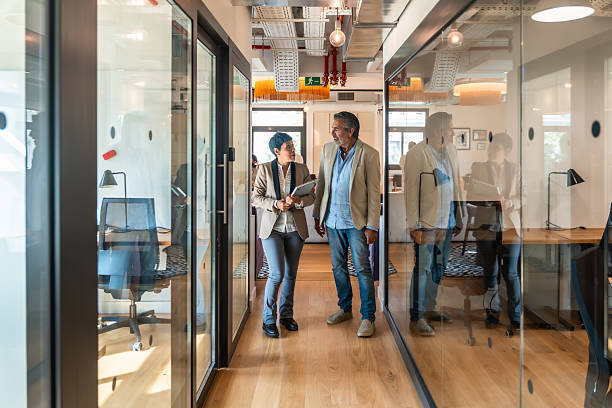 istock Business colleagues walking hallway talking collaborating coworking space 2247758827