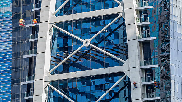 Washers wash the windows of modern skyscraper in Dubai timelapse, UAE. Close up view at sunny day