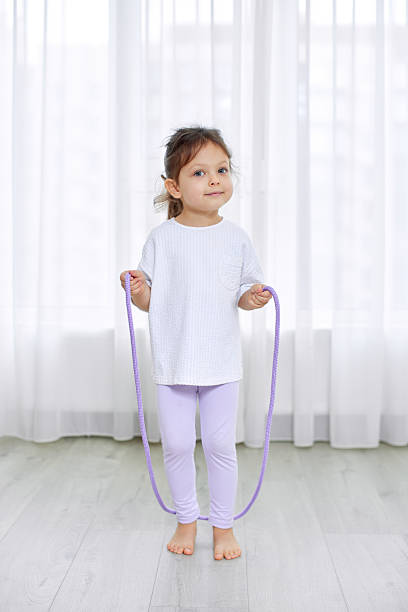 istock Young girl holding skipping rope playing barefoot 2247759907