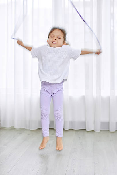 istock Young girl skipping rope feeling joy indoors 2247759928