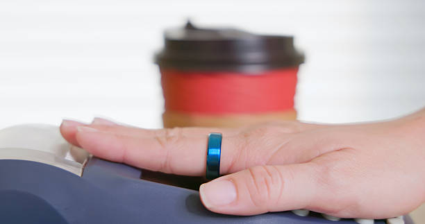 Customer using a smart ring for mobile payment at a coffee shop - demonstrating contactless transaction and wearable technology innovation in modern lifestyle