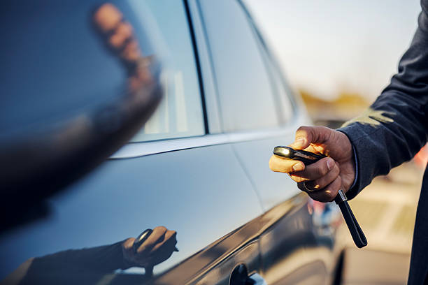 istock Man unlocking car with key fob remote control 2247760262