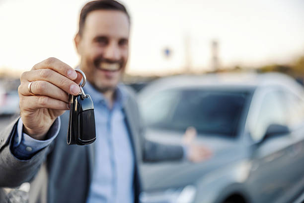 istock Happy man holding new car keys smiling at camera 2247760877
