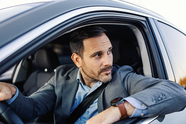 istock Businessman driving car looking back parking 2247760929