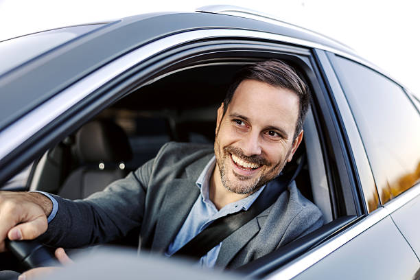 istock Happy businessman driving car looking away 2247760935