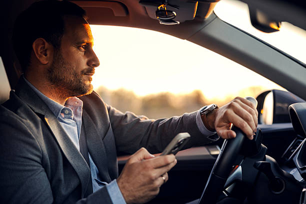istock Businessman driving car and texting on smartphone 2247760947