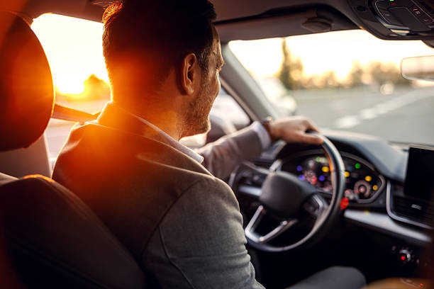istock Businessman driving car during a sunset road trip 2247760961