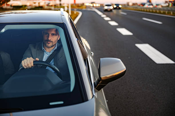 istock Businessman driving car on highway during evening commute 2247760995