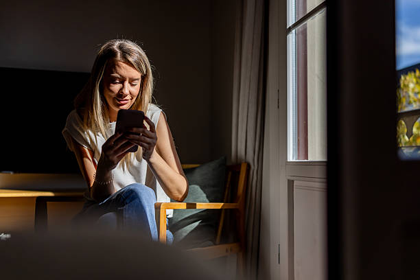 istock Woman Using Smartphone By Window Inside Home, Quiet Morning Moment Of Focus 2247762206
