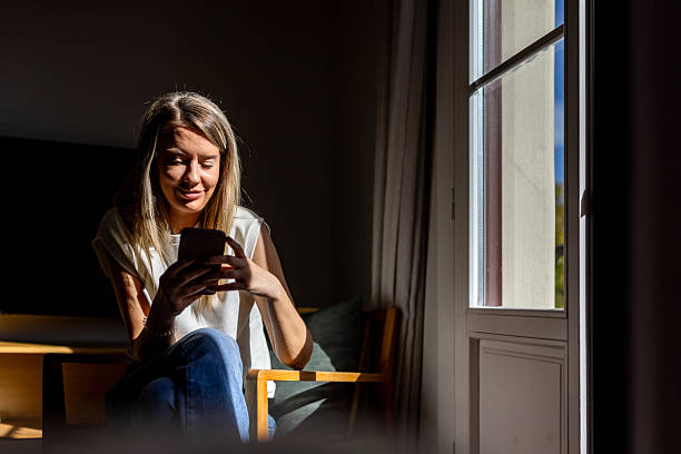 istock Relaxed Woman Using Smartphone by Window Sunlight in Quiet Home Office 2247762228