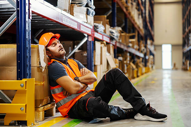 istock Tired warehouse worker sleeping on the job, feeling exhausted 2247764144
