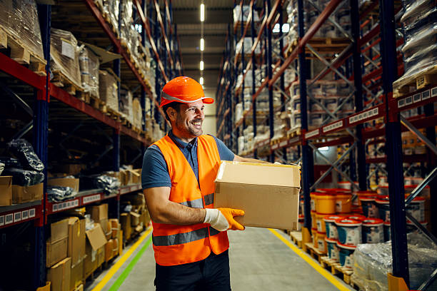 istock Warehouse worker carrying box walking in aisle 2247764338