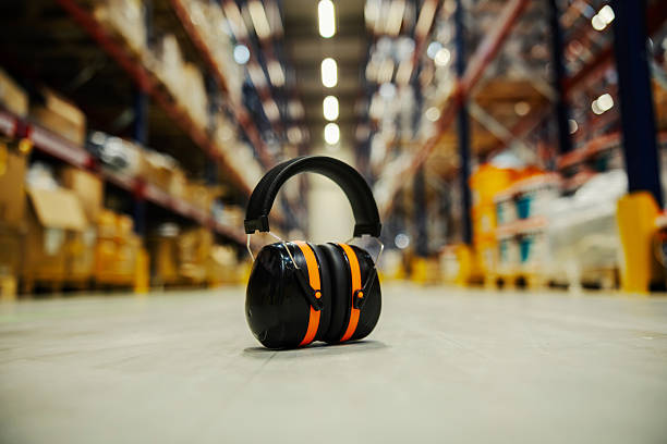 Hearing protection earmuffs resting on a clean warehouse floor, emphasizing safety in industrial environments and logistics