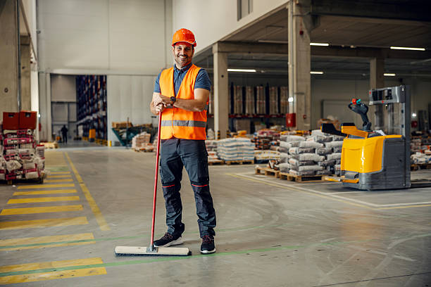 istock Smiling warehouse worker holding broom cleaning facility 2247764534
