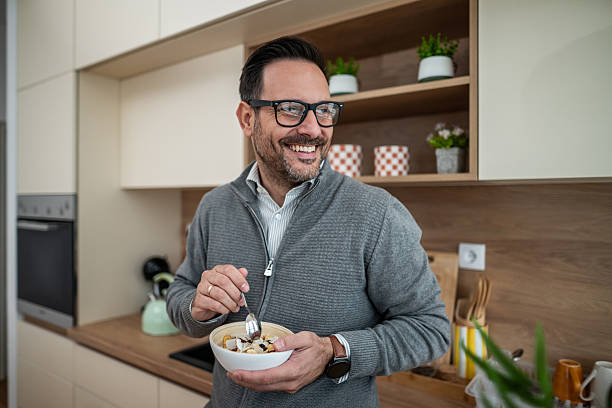 istock Happy man eating healthy breakfast cereal at home 2247764650