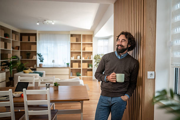 istock Happy man enjoying coffee at home with relaxed smile 2247764842