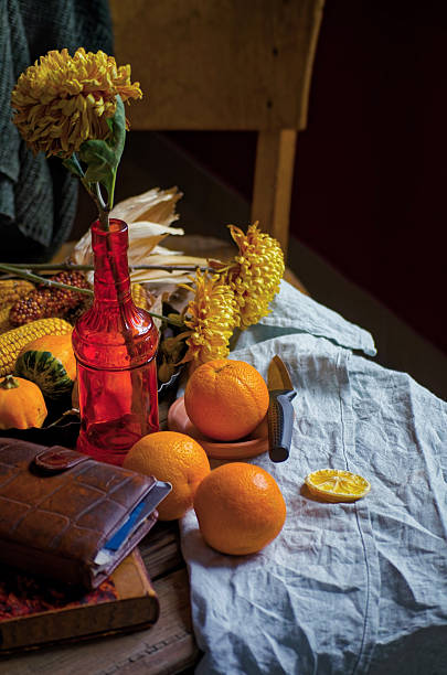 A warm, rustic winter scene featuring fresh oranges, yellow chrysanthemums, dried citrus slices, and natural autumnal elements. Styled with cozy textures and vintage props, this image captures the simplicity of healthy seasonal living. Perfect for themes of immunity, slow living, and natural wellness.