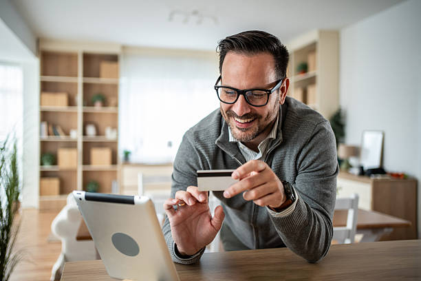 istock Man shopping online using tablet and credit card 2247766592