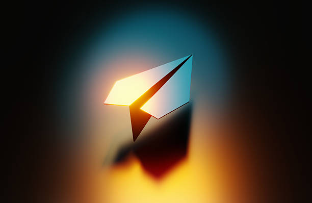 istock Blue Paper Plane Illuminated By Orange And Yellow Lights On Black Background 2247766775