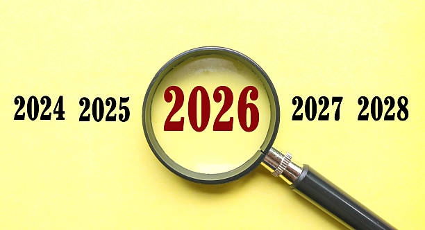 istock New Year 2026 is enlarged using a magnifying glass on yellow background. 2026 highlighted through a magnifying glass, with 2025 and 2027 displayed on each side 2247768757