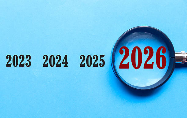istock New Year 2026 is enlarged using a magnifying glass on blue background. 2026 highlighted through a magnifying glass, with 2025 and 2027 displayed on each side 2247768793