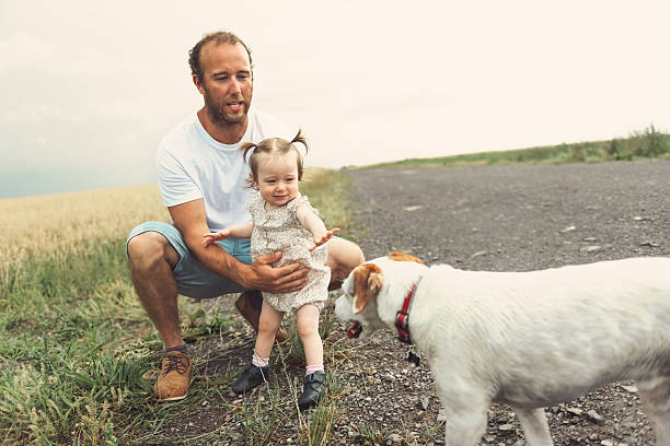 istock father with baby on a field with bad dog in front 2247773152