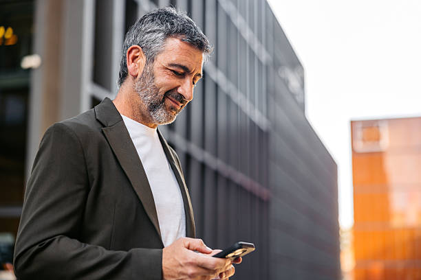 istock Mature Man Using Phone While Standing On The Street In Barcelona In Spain 2247776115