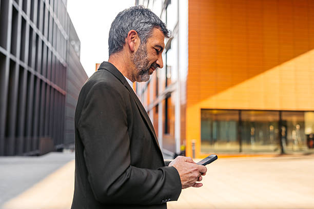 istock Mature Man Using Phone While Standing On The Street In Barcelona In Spain 2247776244