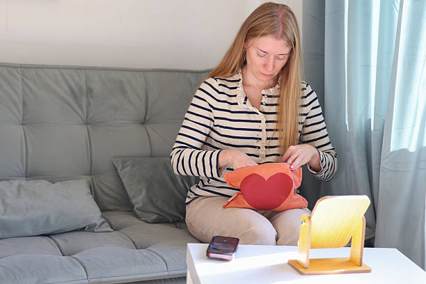 istock Woman sitting on sofa and putting on makeup, simple home beauty routine scene 2247777149