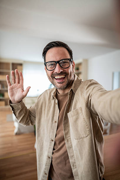 istock Happy man taking selfie and waving during video call 2247780593