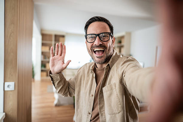 istock Man smiling and waving hand during video call 2247780596