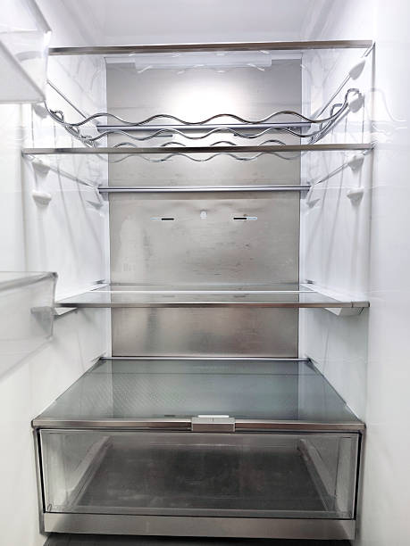 istock Clean, empty refrigerator interior with transparent plastic shelves, metal wine rack, clear storage drawers, and LED lighting. Modern kitchen appliance with organized compartments and minimalistic design. 2247781291