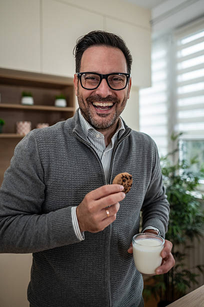 istock Happy man enjoying cookie and milk at home 2247781754
